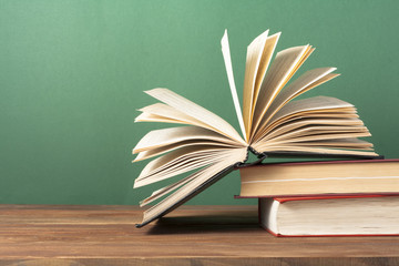 Open book, hardback books on wooden table. Education background. Back to school. Copy space for text.