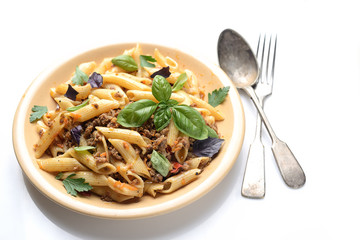 pasta with meat and basil on a plate on a white background