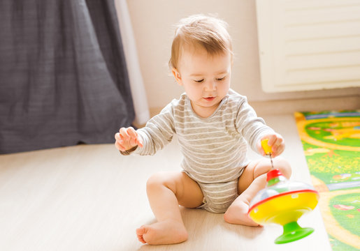 baby boy playing with toy indoors at home
