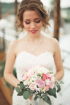 Bride holding big wedding bouquet on ceremony with perfect landscape