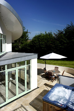 A view looking down into a garden with a patio and hot tub 