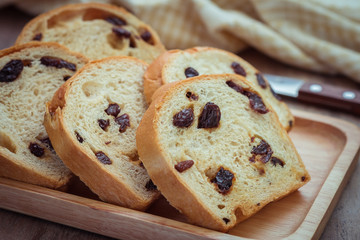 Sliced raisin bread on wooden plate