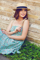 Sunny lifestyle fashion portrait of young stylish hipster woman wearing straw hat.