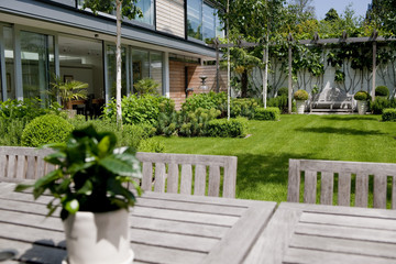 Modern garden and table in the grounds of a contemporary house.