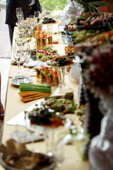 A look from afar on a dinner table full of appetizers and glassw