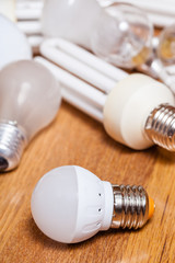 energy saving LED lamp and pile of old bulbs