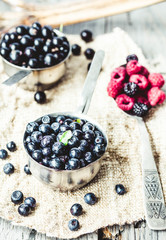 fresh blueberries, currants and raspberries in the metallic plat