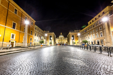 The Conciliazione Road to St. Peter square for from Pia square at night. Vatican City in Rome, Ital