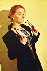 The young beautiful girl walks on the street in a coat and hat w