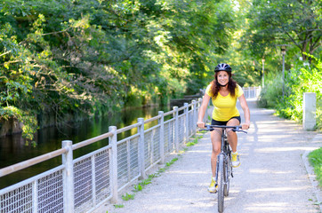 Attractive active young woman riding a bicycle