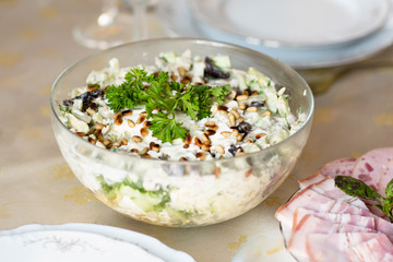 Meat snack for dinner on the dinner table. Salad with duck, mushroom, cucumber and plum with mayonnaise in a glass dish.