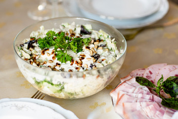 Meat snack for dinner on the dinner table. Salad with duck, mushroom, cucumber and plum with mayonnaise in a glass dish.