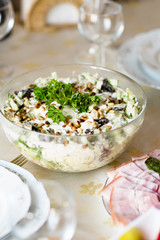 Meat snack for dinner on the dinner table. Salad with duck, mushroom, cucumber and plum with mayonnaise in a glass dish.