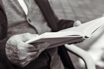 old man reading a book, in black and white