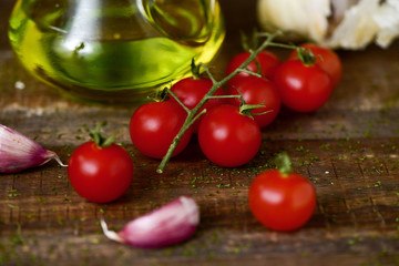 olive oil, tomatoes and garlic on a wooden table