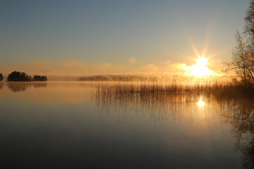 Fototapeta na wymiar Sunrise on the lake with haze.