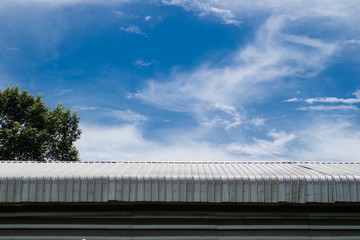 Fototapeta na wymiar Metal sheet roof building with blue sky background