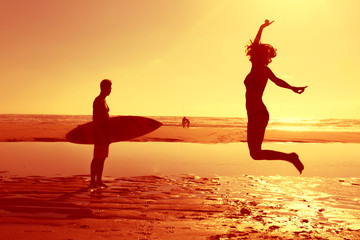 Fototapeta premium happy woman jumping in sea beach sunset silhouette. holiday vacation concept.