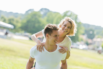 Man giving piggyback ride- carrying on the back his girlfriend