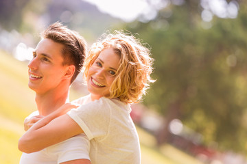 Man giving piggyback ride- carrying on the back his girlfriend