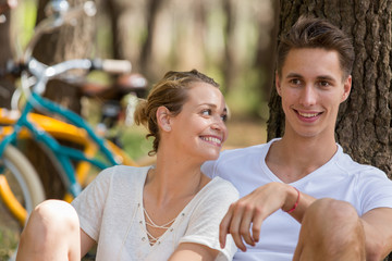 couple with bicycles resting in forest