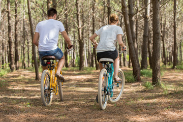 couple of cyclists riding bicycles on sunny summer day