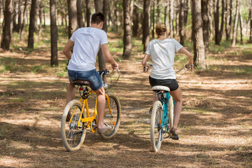 Obraz premium couple of cyclists riding bicycles on sunny summer day