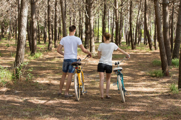 Obraz premium couple of cyclists riding bicycles on sunny summer day