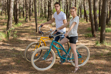 Fototapeta premium couple of cyclists riding bicycles on sunny summer day