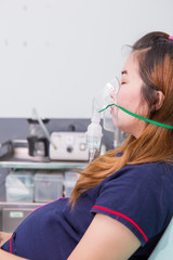 woman breathing through Inhaler Mask In emergency room