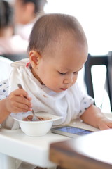 baby boy eating ice cream and Playing smartphone.