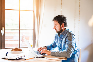 Man sitting at desk working from home on laptop