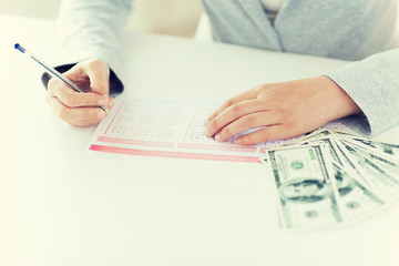 Fototapeta premium close up of hands with lottery ticket and money