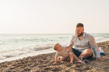 Dad with a baby boy resting on the beach