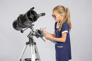 Young girl with glasses writes astronomer observations