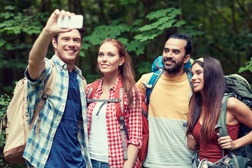 friends with backpack taking selfie by smartphone