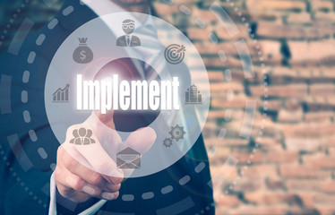 A businessman selecting a Implement Concept button on a circular panel