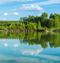 Beautiful lake landscape with sky and trees reflected in the water