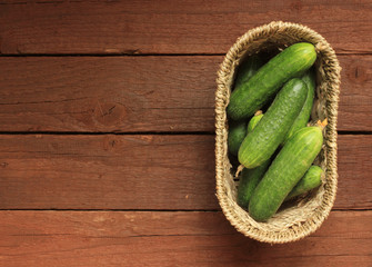 Cucumbers in a basket on wooden background