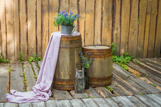 two barrels in the background of a wooden wall decorated with lavender and purple cloth