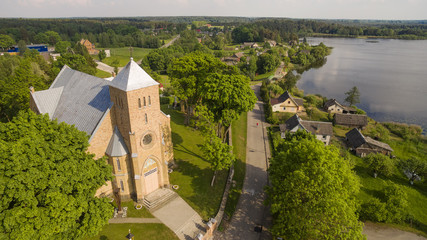 Naklejka premium AERIAL. Beautiful summer shot of Vepriai church and lake 