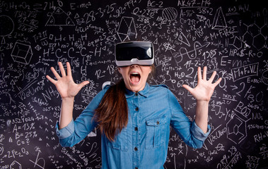 Beautiful woman wearing virtual reality goggles against big blac