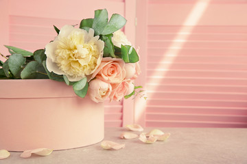 Beautiful bouquet of flowers on pink gift box