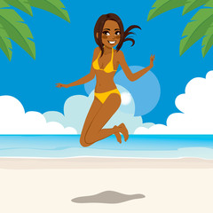 African American woman in bikini jumping happy on tropical beach