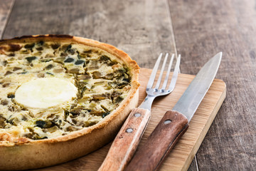 French quiche Lorraine with vegetables on a rustic wooden table

