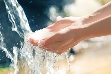 Fototapeta premium Water dropping from woman's hands