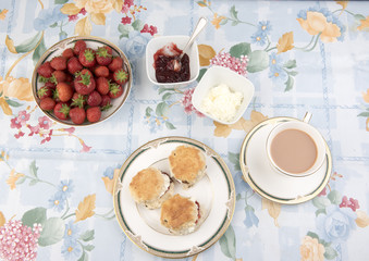 Image  of scones with jam, cream, tea and strawberries  