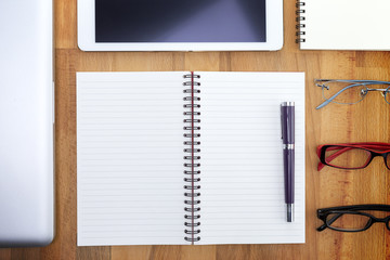 Businessman write a short note on opened notebook with pen and glasses. Flat layout and copy space.