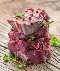 Pieces of beef tenderloin on the wooden cutting board.