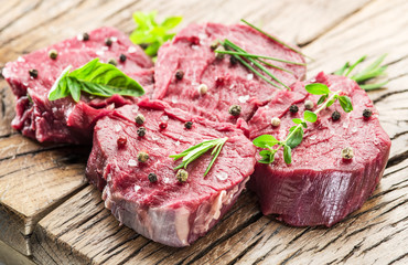 Pieces of beef tenderloin on the wooden cutting board.